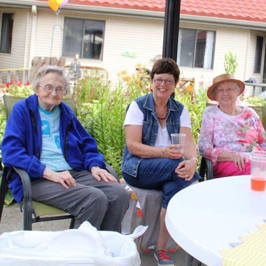 Donate - two residents and one volunteer enjoying outside
